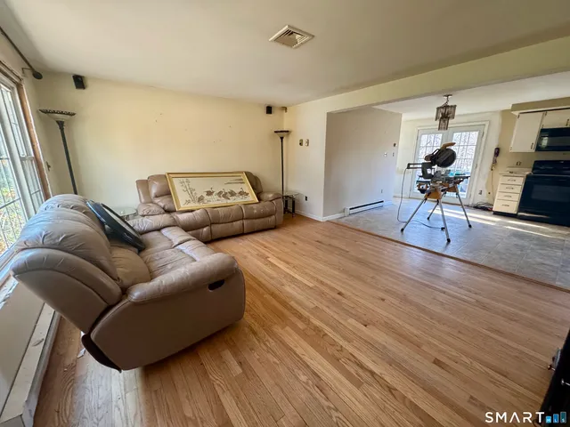 a living room with furniture and a wooden floor