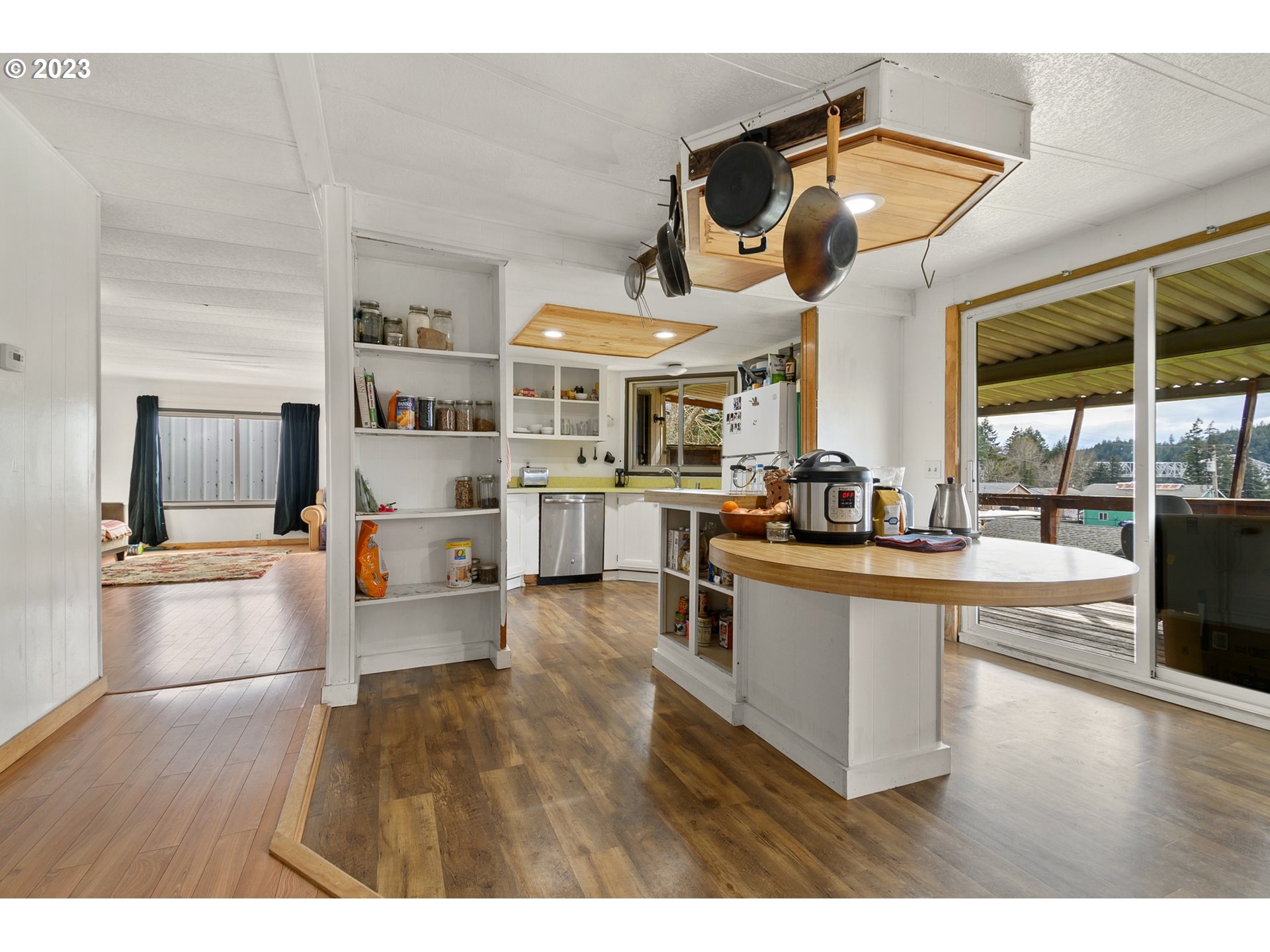 126 Southwest Venture Street Cascade Locks, OR 97014 - Photo 5 of 16 a kitchen view with stainless steel appliances wooden floor and large windows