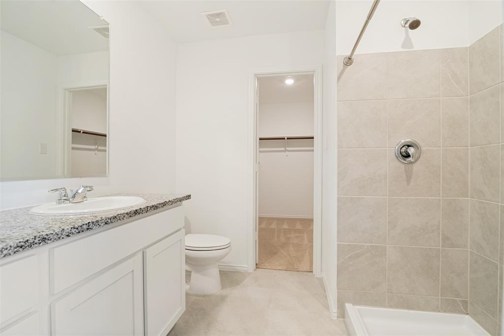 1345 Cider Street Forney, TX 75126 - Photo 10 of 15 a bathroom with a granite countertop sink a toilet and shower