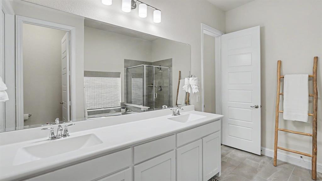 5213 Ravine Ridge Court Flower Mound, TX 76262 - Photo 22 of 40 Double vanity featuring undermount sinks, chrome faucets, and white cabinetry.