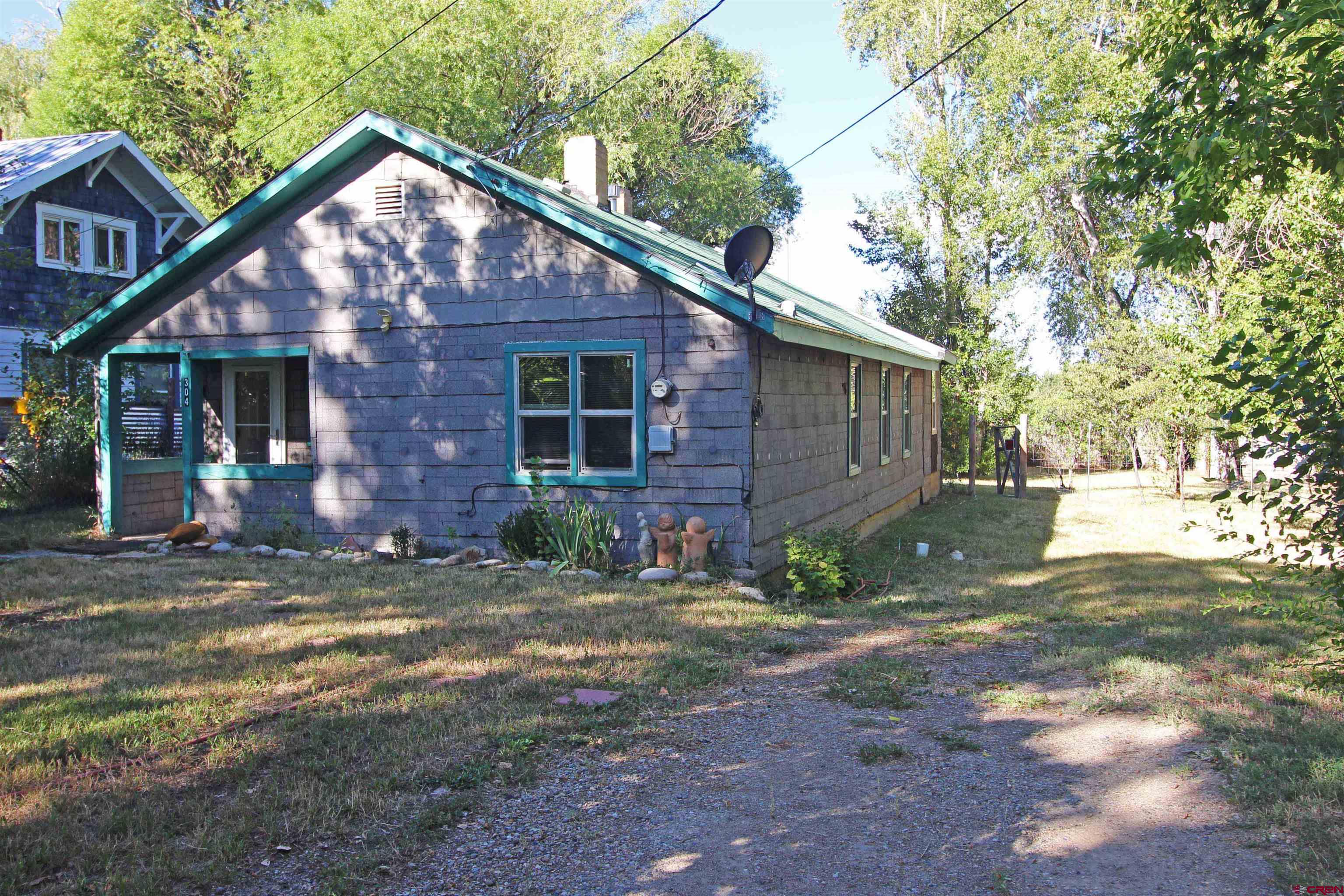 304 South Walnut Street Mancos, CO 81328 - Photo 1 of 31 a front view of a house with garden