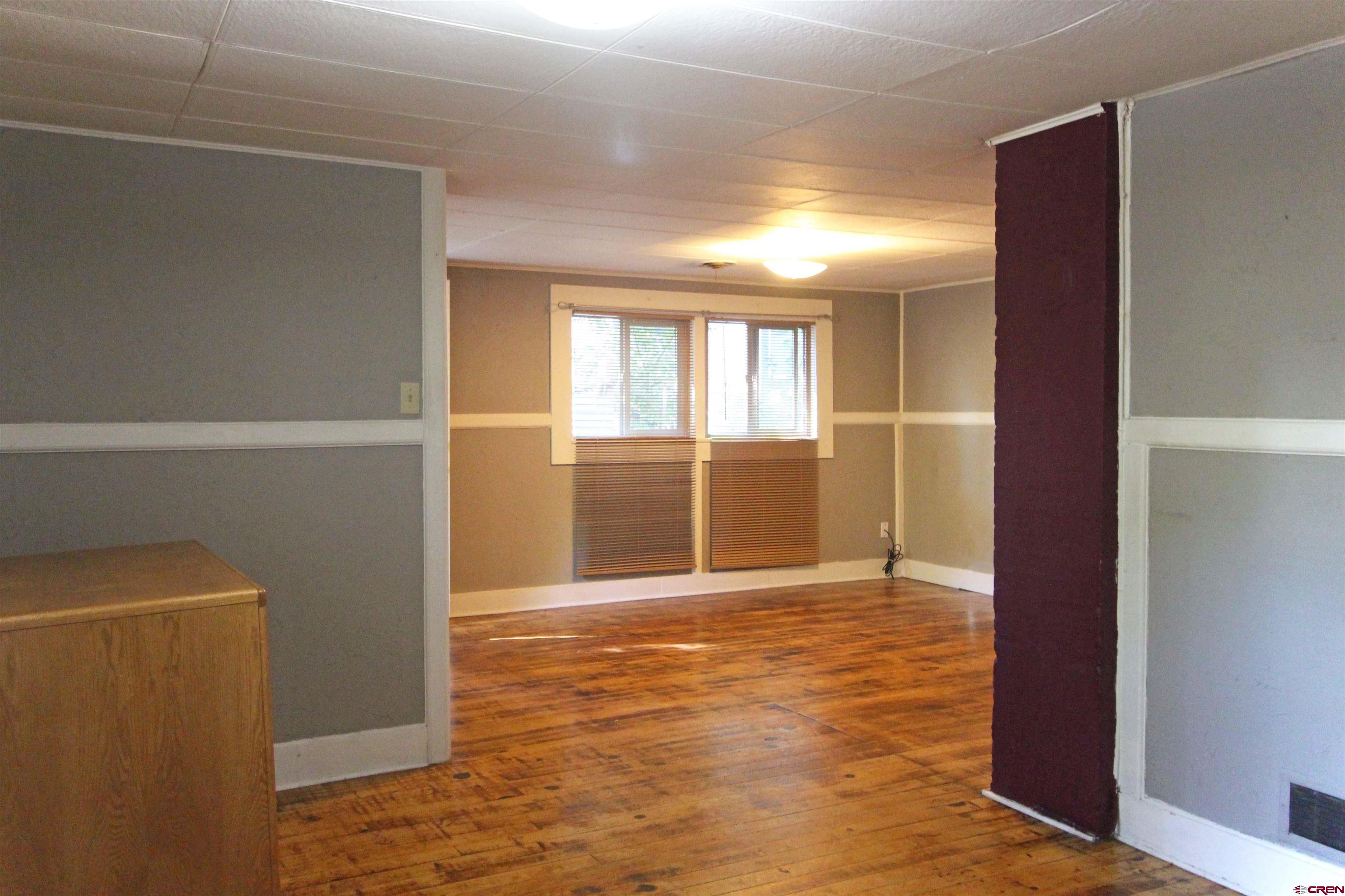 304 South Walnut Street Mancos, CO 81328 - Photo 6 of 31 a view of an empty room with wooden floor and a window