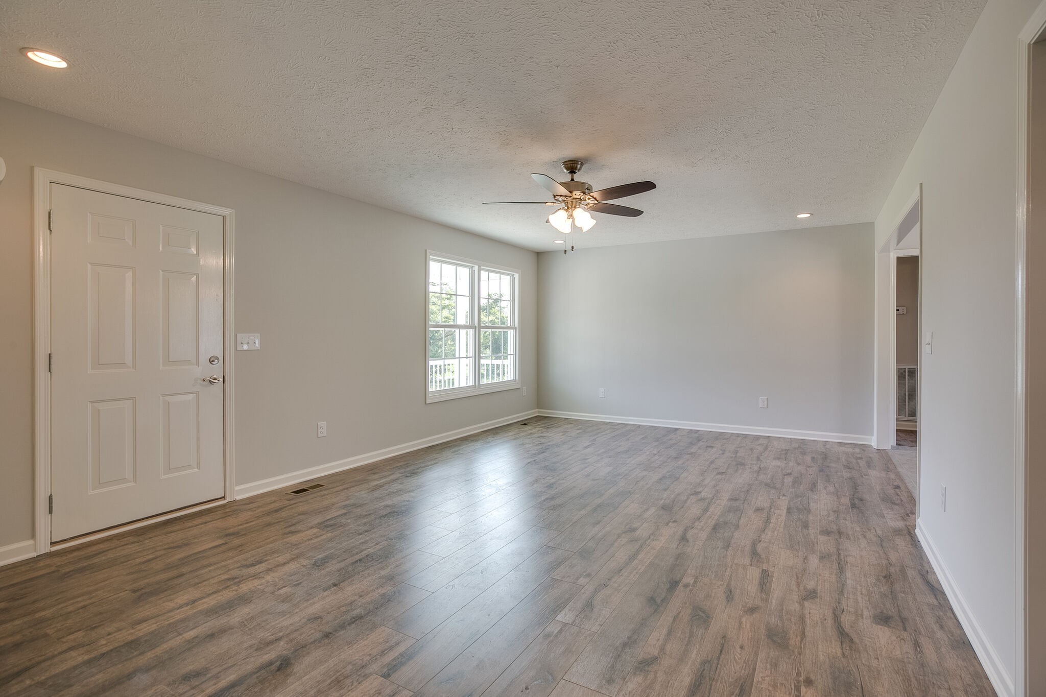 713 Jarrell Road Manchester, TN 37355 - Photo 3 of 25 a view of an empty room with a window and wooden floor