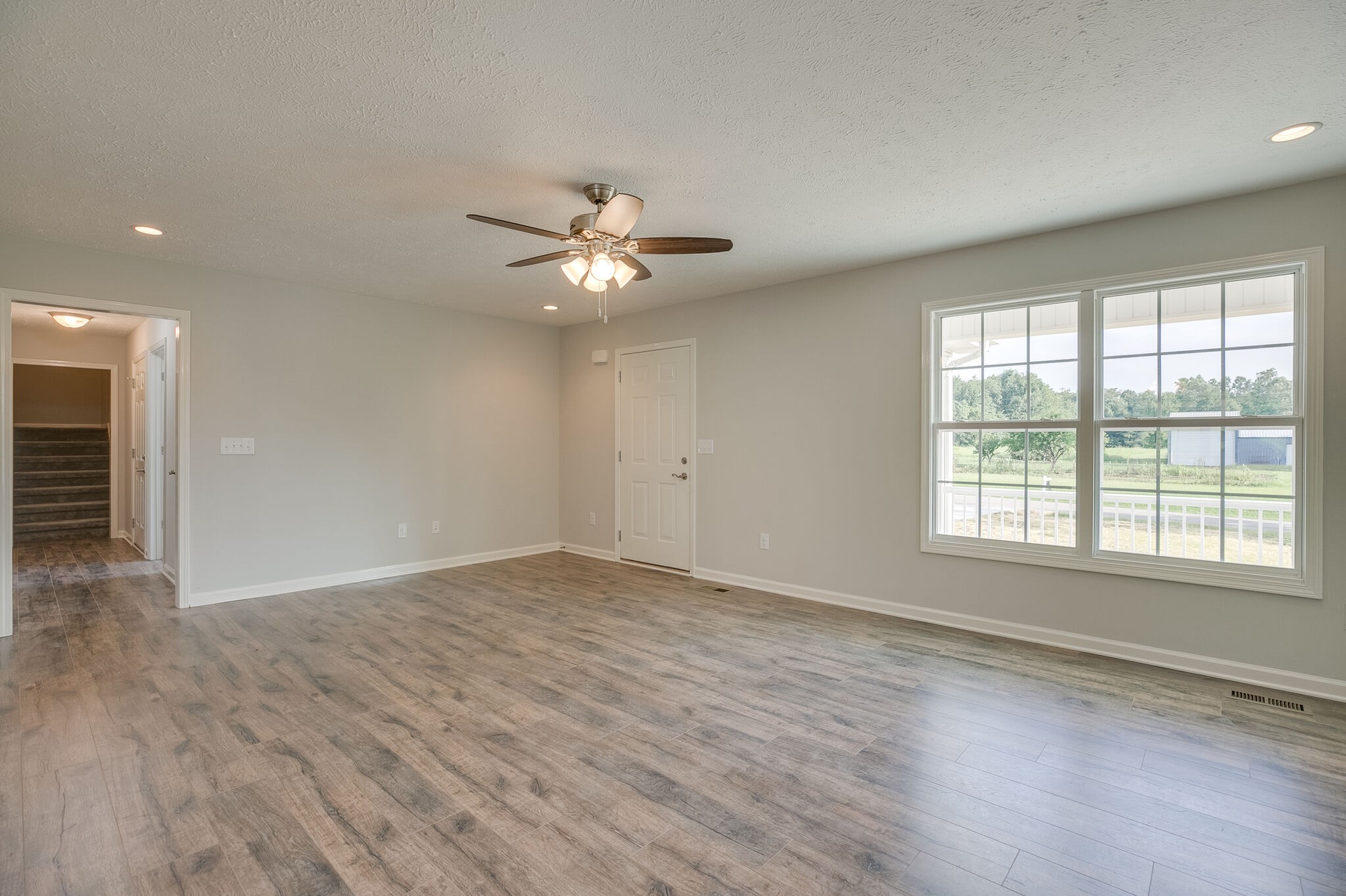 713 Jarrell Road Manchester, TN 37355 - Photo 4 of 25 an empty room with wooden floor and windows