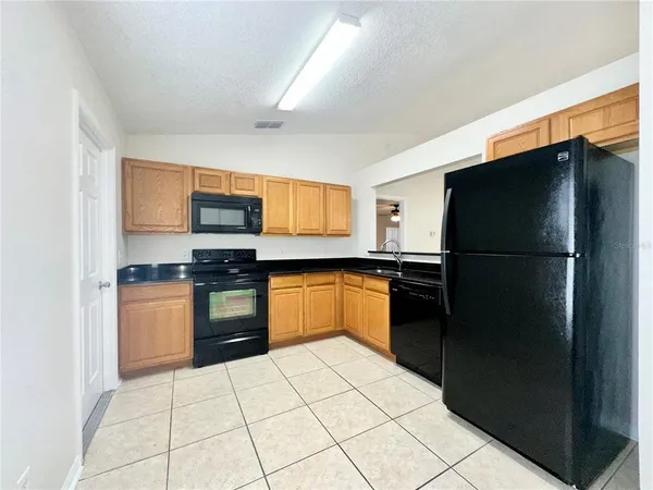a kitchen with a refrigerator and a stove top oven