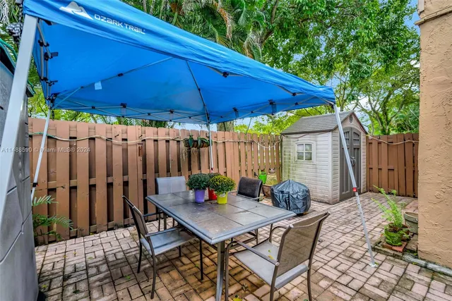 a view of a backyard with table and chairs under an umbrella
