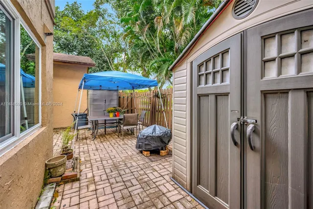 a view of a patio with a table and chairs and floor to ceiling window