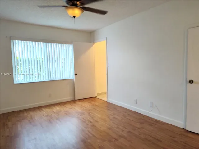 an empty room with wooden floor and a window