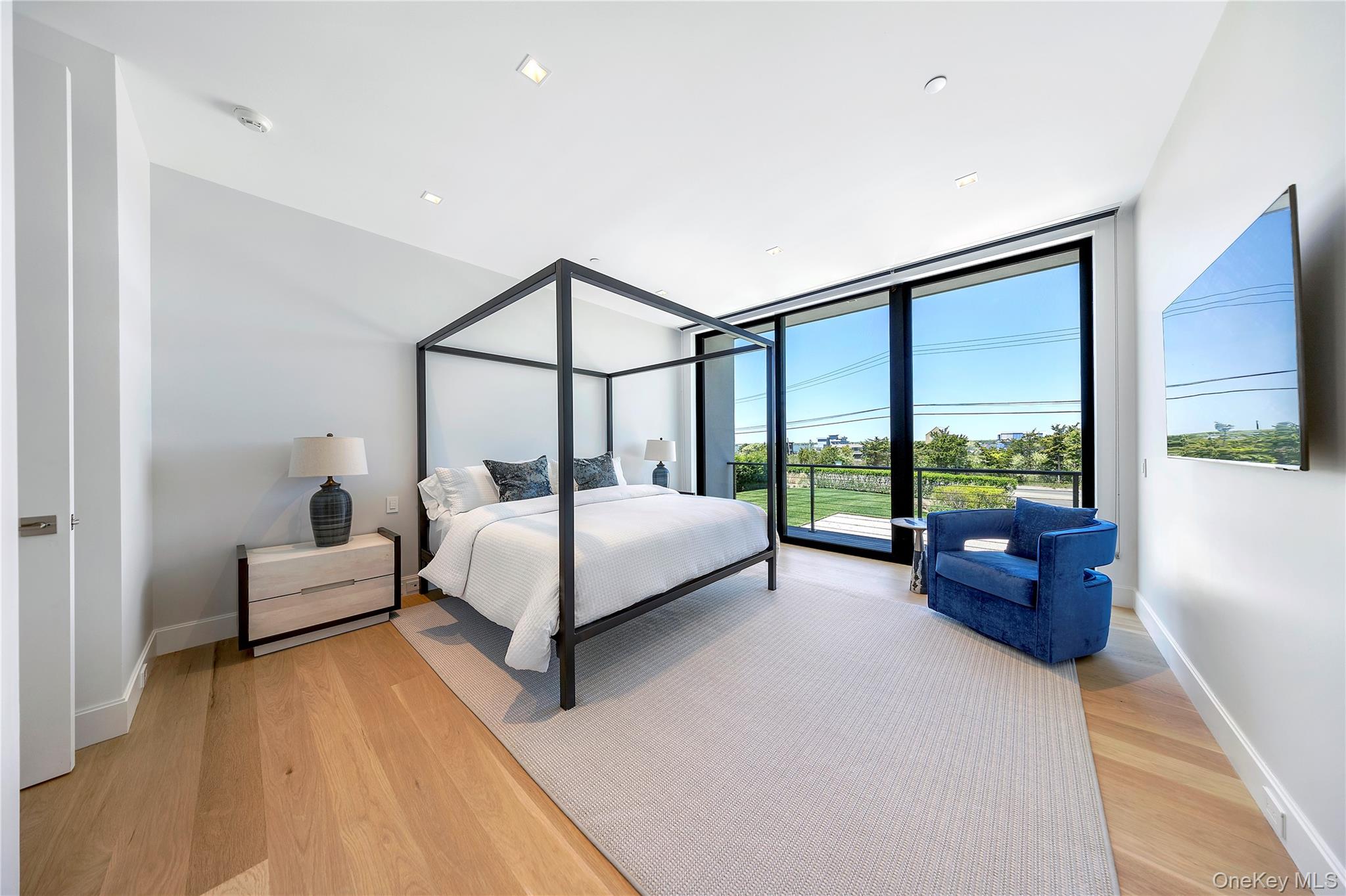 345 Dune Road Westhampton Beach, NY 11978 - Photo 19 of 34 Bedroom with floor to ceiling windows and light wood finished floors
