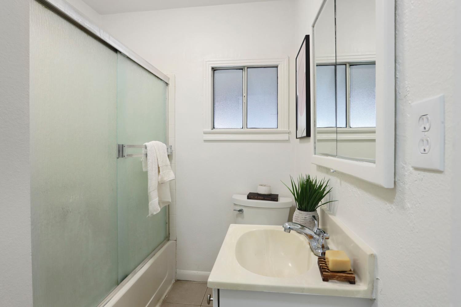 1436 Teresa Street Modesto, CA 95350 - Photo 19 of 32 a bathroom with a sink a mirror and a toilet