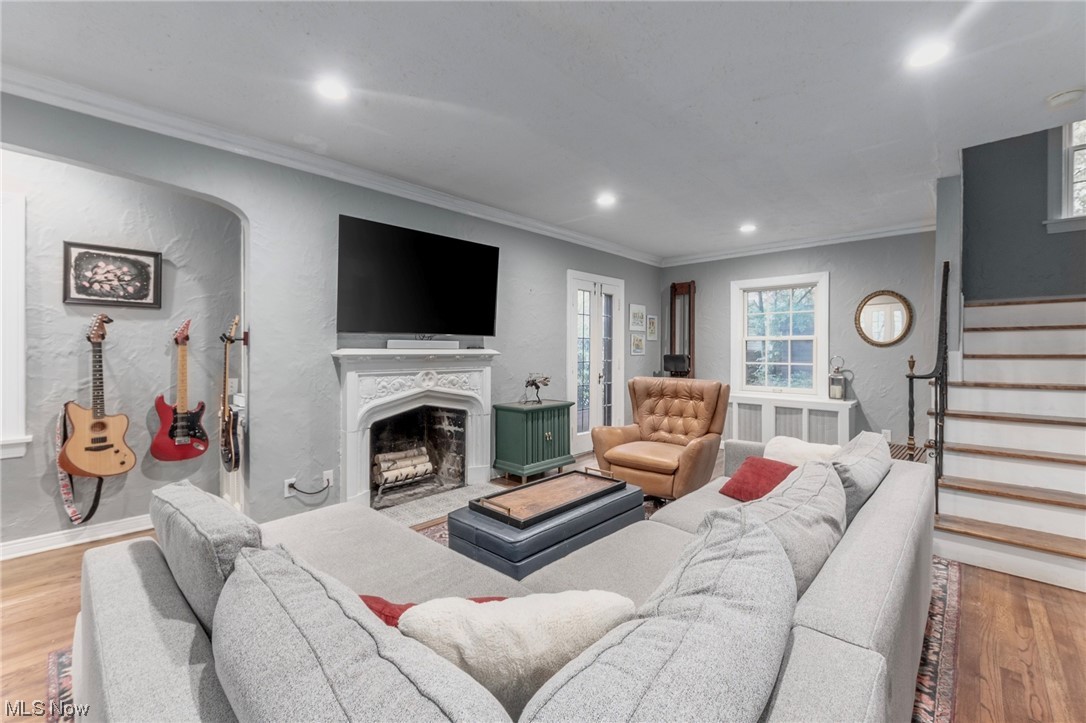 Living room with crown molding and light hardwood floors