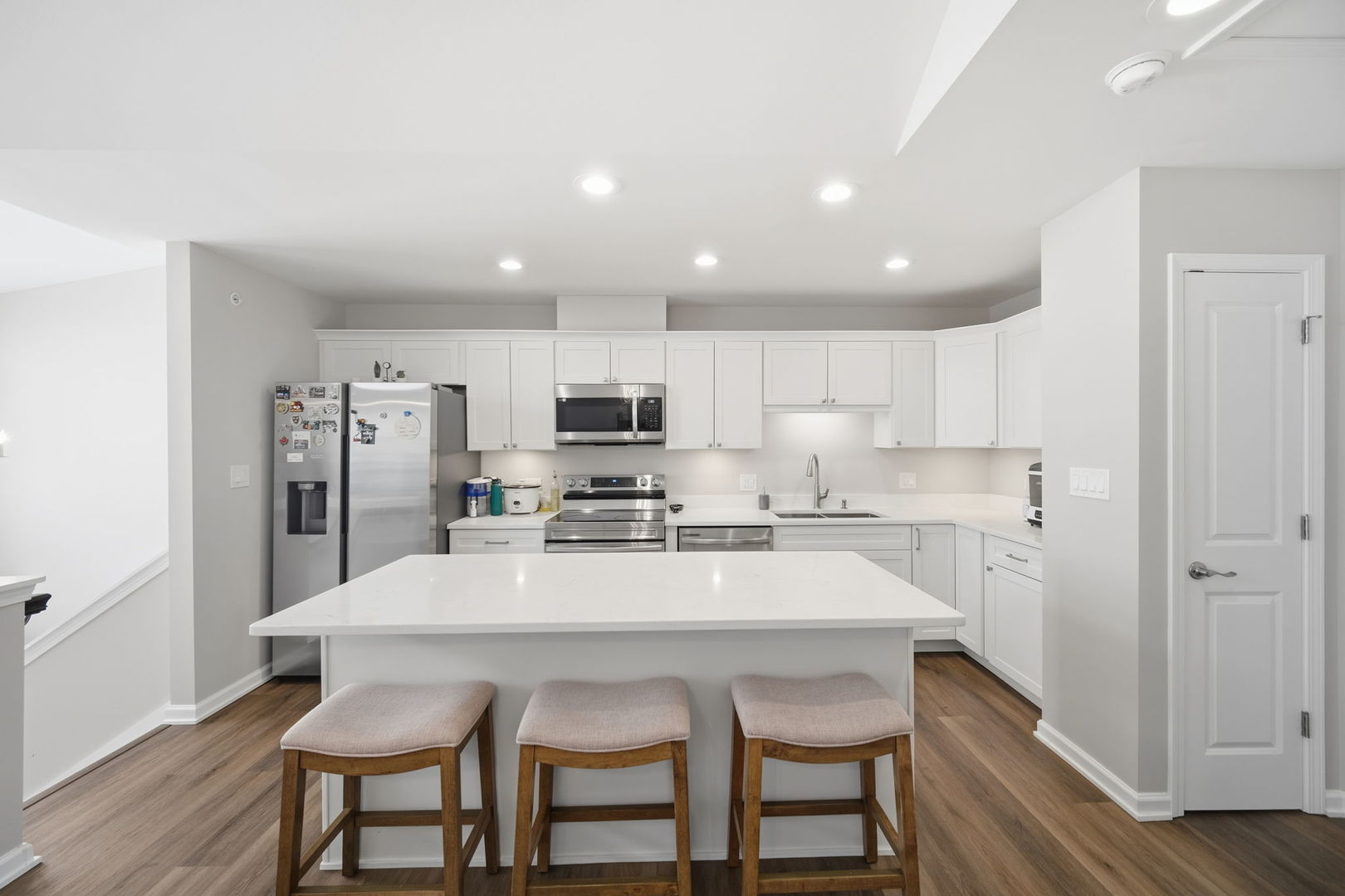 7214 Farmstead Lane Hanover Park, IL 60133 - Photo 11 of 30 a kitchen with stainless steel appliances a dining table chairs refrigerator and microwave