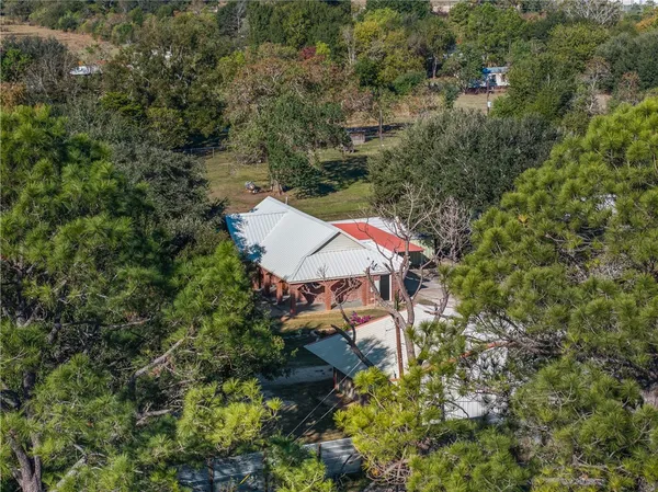 an aerial view of a house with yard and outdoor seating