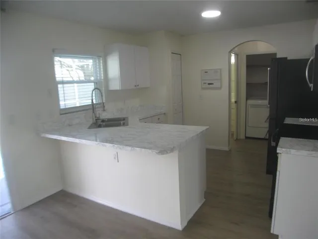 a kitchen with stainless steel appliances granite countertop a sink and a refrigerator