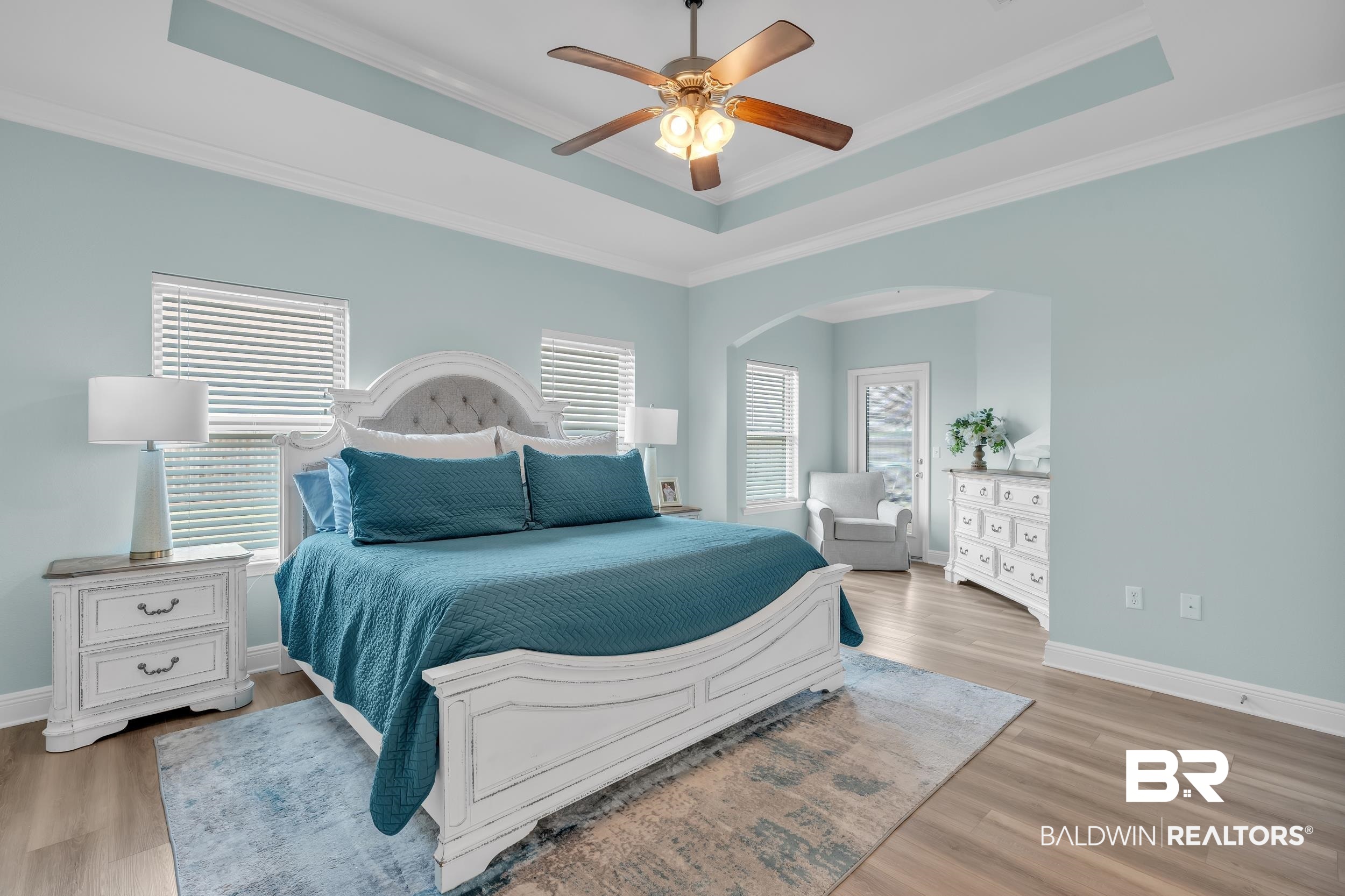 7109 Rocky Rd Loop Gulf Shores, AL 36542 - Photo 18 of 30 Bedroom featuring wood finished floors, ornamental molding, arched walkways, a raised ceiling, and baseboards