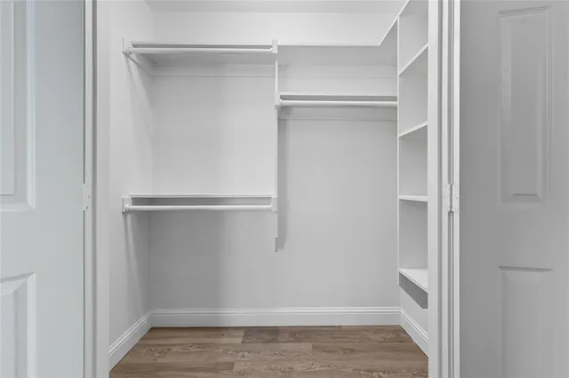 a view of walk in closet with empty racks