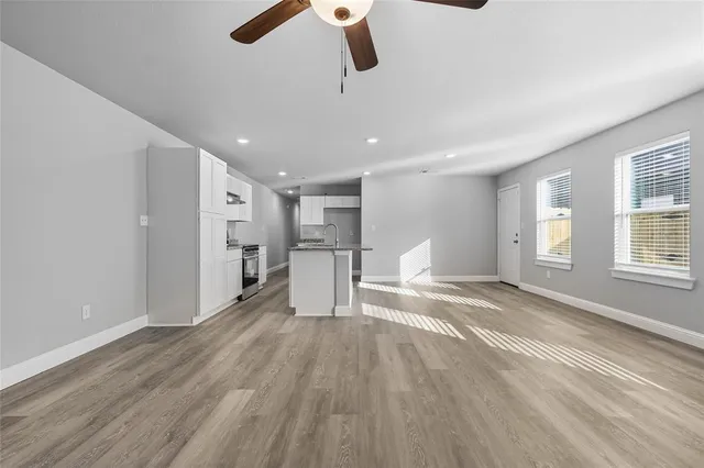 a view of empty room with wooden floor and windows
