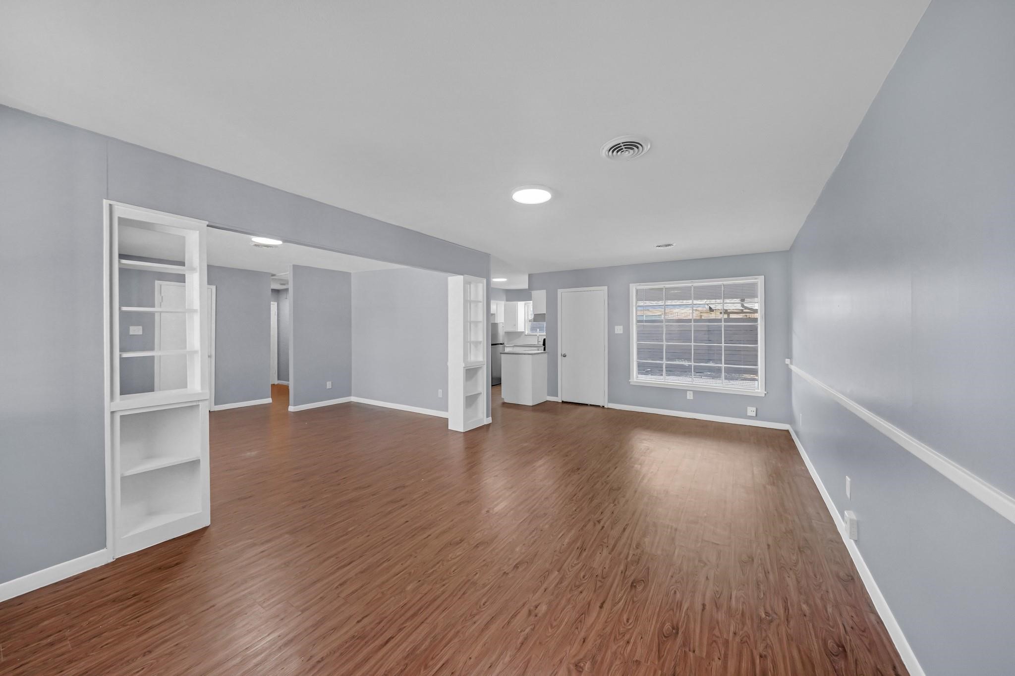 11202 Waxwing Street Houston, TX 77035 - Photo 3 of 19 a view of an empty room with a window and wooden floor
