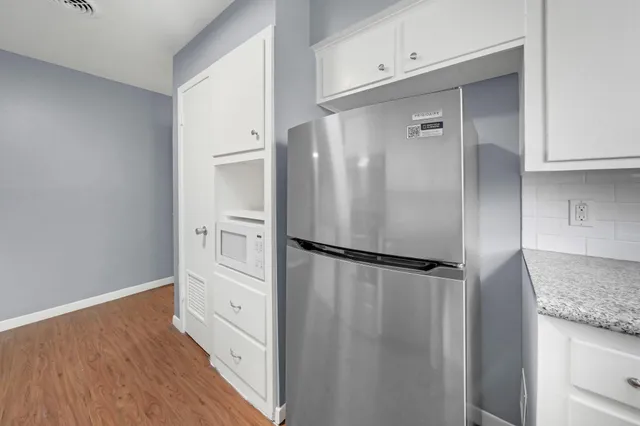 a kitchen with stainless steel appliances granite countertop a refrigerator and a stove top oven