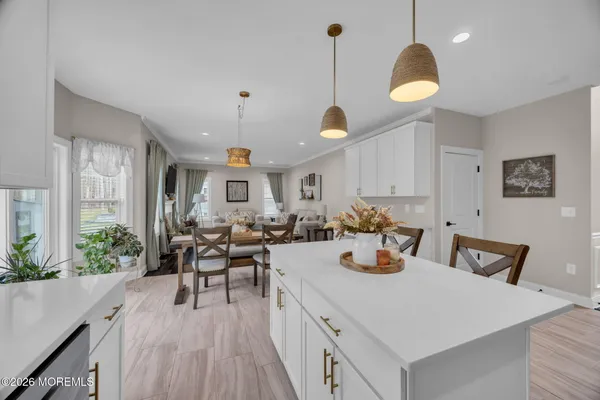 a view of a dining room and livingroom with furniture wooden floor a chandelier