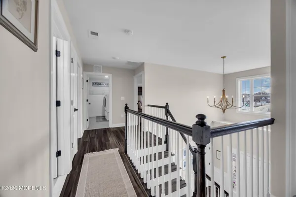 a view of a hallway with a hardwood floor and stairs