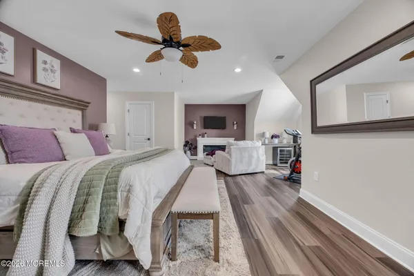 a spacious bedroom with a bed and ceiling fan