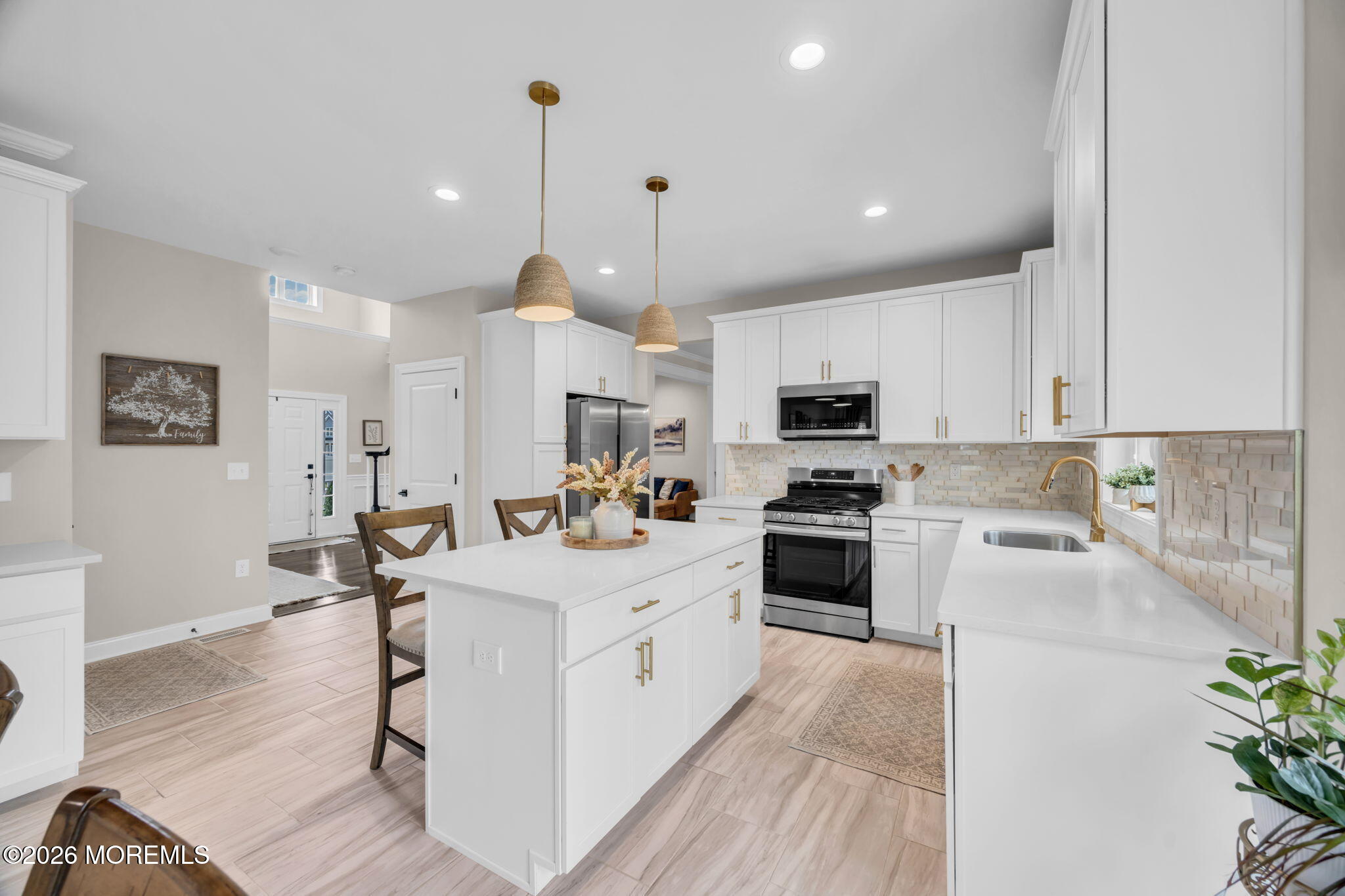 10 Tasha Lane Howell, NJ 07731 - Photo 3 of 44 a large white kitchen with stainless steel appliances granite countertop a stove a sink a refrigerator and a dining table with wooden floor