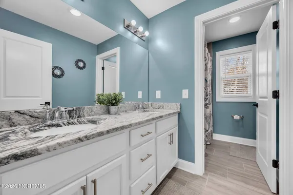 a bathroom with a granite countertop sink and a mirror