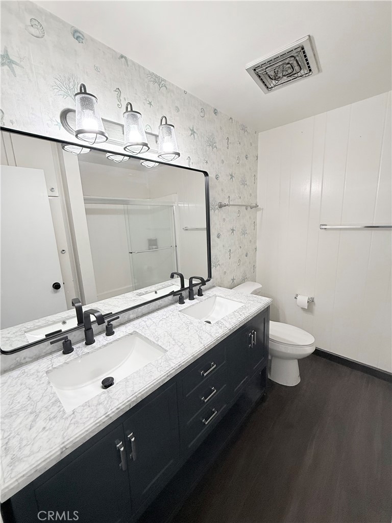 12200 Montecito Road, Unit D221 Seal Beach, CA 90740 - Photo 10 of 25 Remodeled bathroom with dual sinks, granite counter tops and newer mirror and light fixture.
