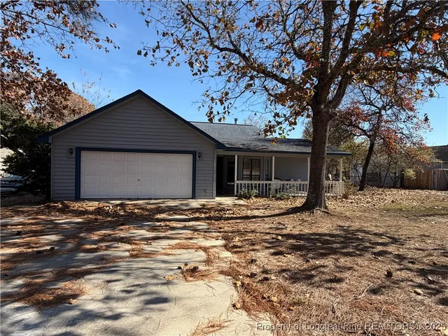a view of a house with a yard and large tree