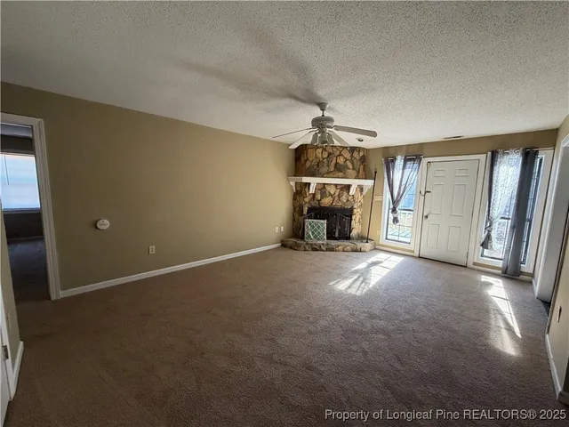a view of empty room with fireplace and windows