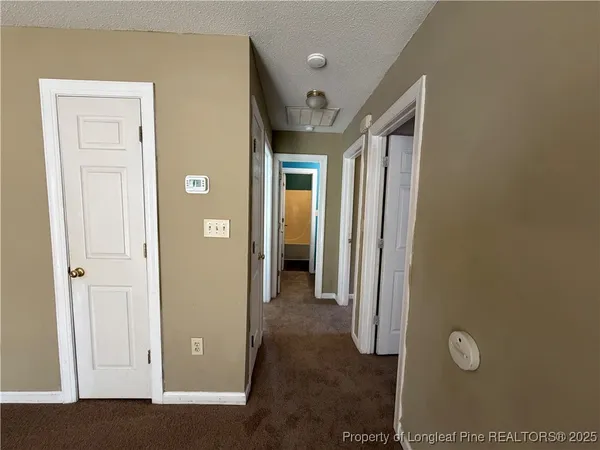 a view of a hallway with wooden floor and closet
