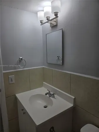 a white bath tub sitting next to a white sink and vanity