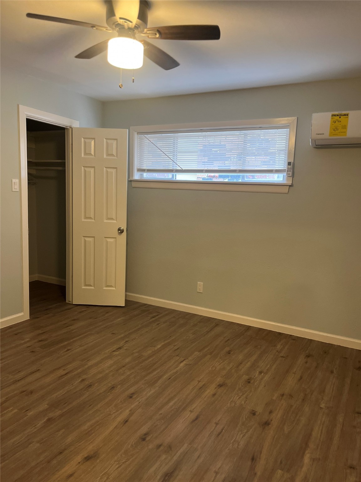 4624 Bell Street, Unit 2 Houston, TX 77023 - Photo 8 of 12 an empty room with wooden floor closet and windows