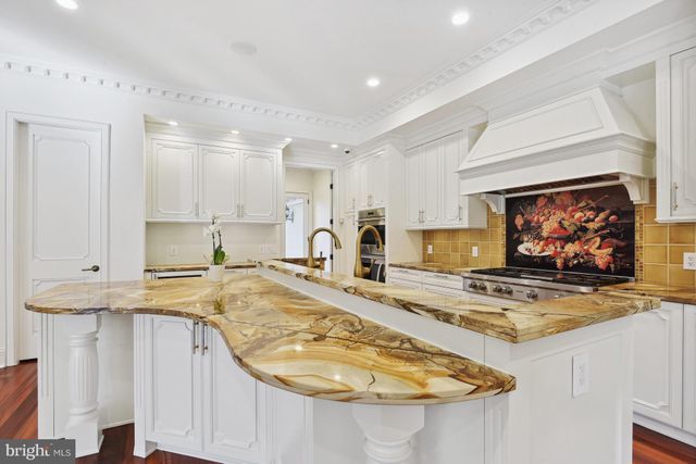 a view of a kitchen with kitchen island a sink and wooden floor