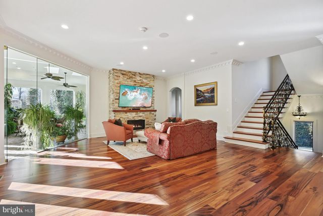 a living room with furniture floor to ceiling window and wooden floor