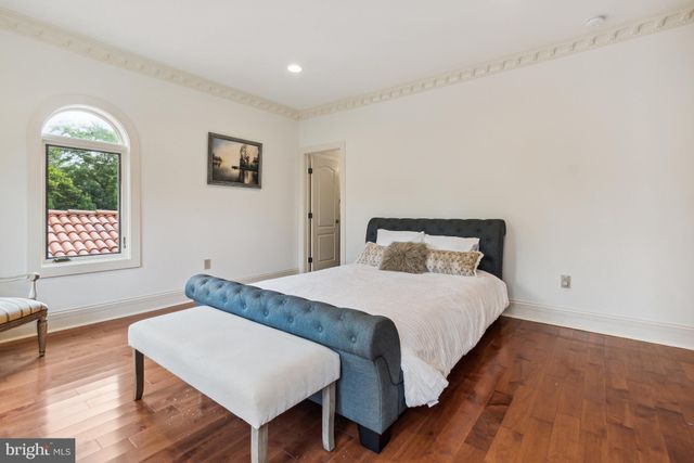 a bedroom with a bed window and wooden floor