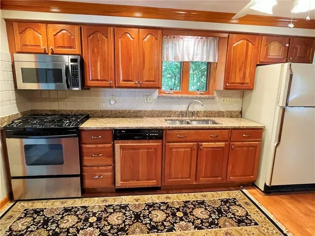 a kitchen with stainless steel appliances granite countertop a refrigerator and a stove