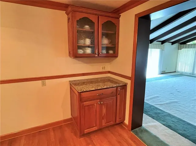 a view of a door and an empty room with wooden floor
