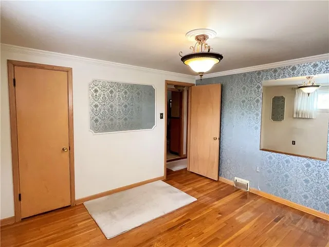 a view of a room with wooden floor and a ceiling fan
