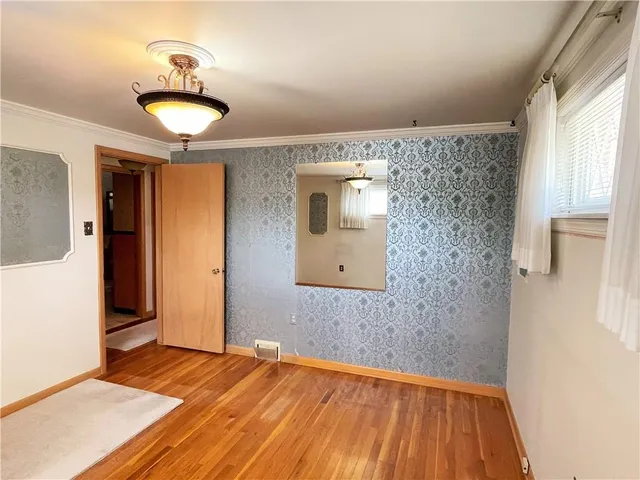 a view of a livingroom with wooden floor and a window