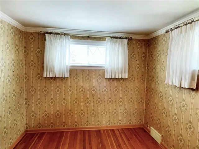 a view of small space with wooden floor and a window