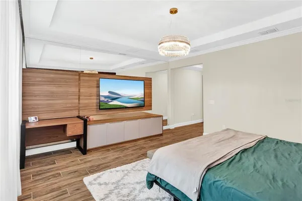 a bedroom with a bed and a flat screen tv