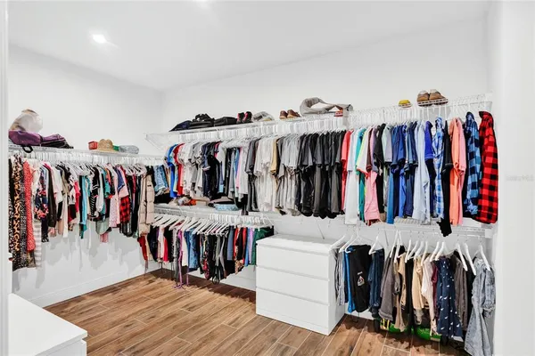 a view of walk in closet with clothes and shoes