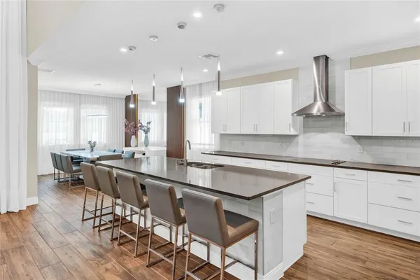 a kitchen with stainless steel appliances granite countertop a table chairs sink and stove top oven