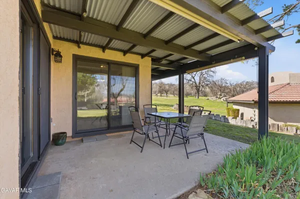 a view of a porch with furniture and a backyard