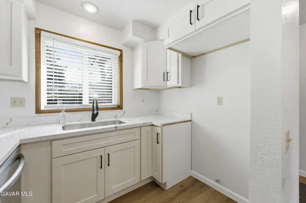 a kitchen with a sink cabinets appliances and a window