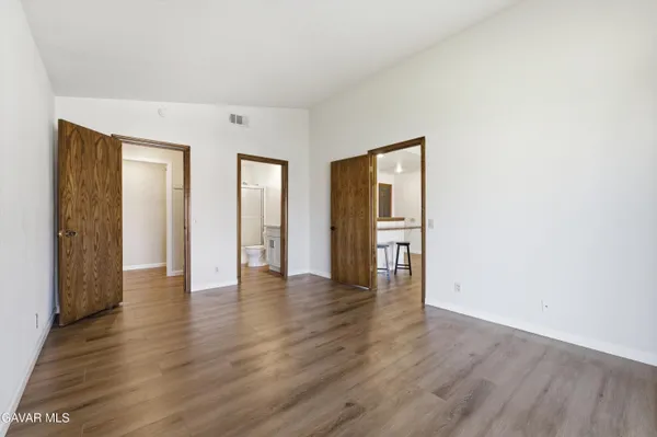 an empty room with wooden floor and closet