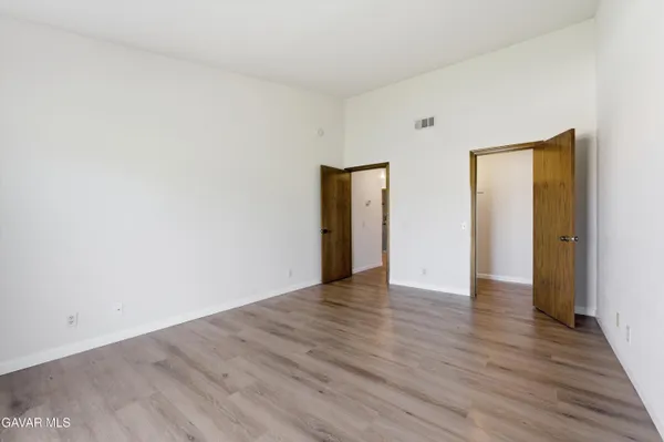 a view of an empty room with wooden floor