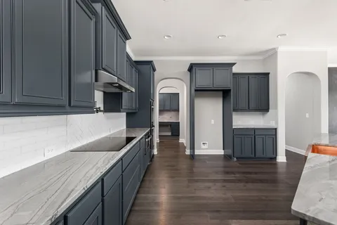 a kitchen with stainless steel appliances granite countertop a refrigerator and a stove top oven